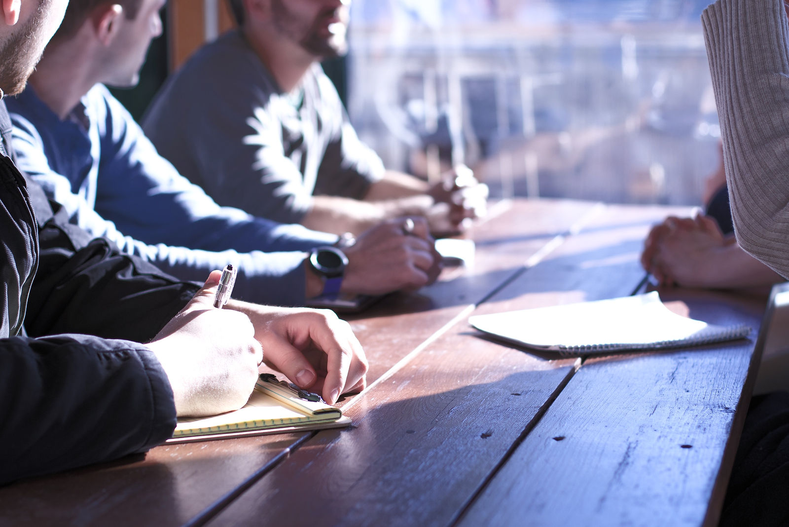 people sitting on chair in front of table while holding pens during daytime_edited.jpg